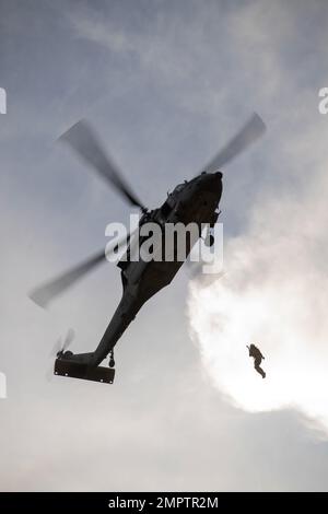 221117-N-EV253-2078 SAN DIEGO (17. Nov. 2022) – Ein US Naval Aircewmen (Helicopter) wendet während eines dynamischen Proof-of-Concept-Kurses dynamische Hebetechniken eines MH-60s Seahawk-Hubschraubers an, der den „Merlins“ der Helicopter Sea Combat Squadron (HSC) 3 zugewiesen wurde. Während des Kurses, der von dem Leiter des Such- und Rettungsmodells (SARMM) des HSC-3 geleitet wurde, arbeiteten Piloten zusammen mit Vertretern von Air Rescue Systems (ARS), die Navy-Piloten und -Besatzungen die physikalischen Grundlagen des Helikopterhobens und neue Techniken lehrten, um eine sichere und effiziente Dynamik zu gewährleisten Stockfoto