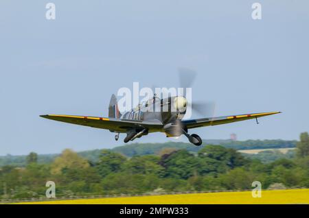 Zweisitzer Supermarine Spitfire MkIXT (Mark 9 Trainer) ML407 G-LFIX Kampfflugzeug startet. Fahrgestell wird eingefahren, über Feld tief Stockfoto