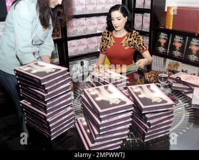 DITA von Teese unterzeichnet Kopien ihres neuen Buches "Dita: Stripteese" bei Books and Books. Während der Veranstaltung begrüßte sie die Fans und bewunderte ein Tattoo von ihr auf dem Bein eines Fans, machte ein Foto davon und nahm einen Kuss von ihm an. Miami Beach, Florida 12/4/09. Stockfoto