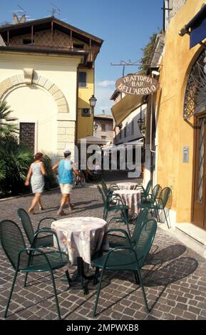 Menschen, die durch gepflasterte Gegend in Gardone, Lombardei, Italien laufen Stockfoto