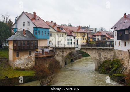 Ein nasser Dezember-Tag in Skofja Loka in Gorenjska, Slowenien. Die Kapuzinerbrücke überquert den Fluss Selska Sora, während sie durch das historische Zentrum fließt Stockfoto