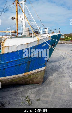 Westlich von Irland Hafen bei Ebbe mit zwei Fischerbooten auf Sand im Hafen von Kilronan Inishmore Aran Islands County Galway Irland. Stockfoto