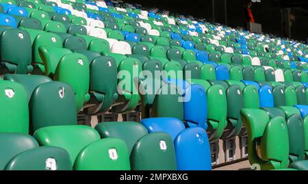 Moderne britische Fußballstadion-Sitzplätze. Reihen mit grün-blau-weißen Klappsitzen im Stadion Windsor Park, Belfast. Stockfoto