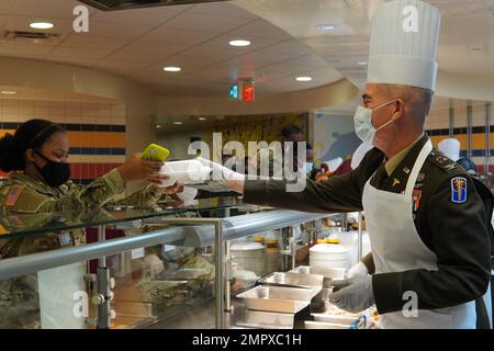 65. Medical Brigade Commander, Oberst Lee A. Burnetts serviert einem Soldaten Thanksgiving-Essen im BDAACH Cafe. Stockfoto