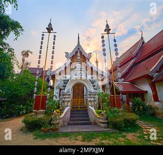 Kunstvoll verziertes Ubosot von Wat Mahawan mit geformtem Stucktor, Holztüren und Giebelenden, verziert mit goldenem Blattwerk, geteiltem Dach mit silbernen Bargeboards, Stockfoto