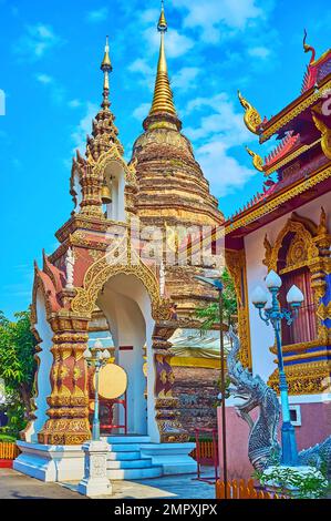 Der kultivierte Stuck-Glockenturm Ho Rakang mit rituellem gong und Glocke vor dem alten Backsteinchädi von Wat Saen Muang Ma (Wat Hua Khuang), Chiang Mai Stockfoto