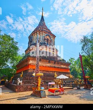 Die kleinen Goldskulpturen und geschnitzte Stangen im Lanna-Stil am mittelalterlichen Ziegelstein Chedi von Wat Lok Moli, Chiang Mai, Thailand Stockfoto