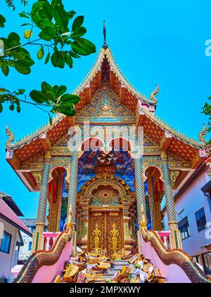 CHIANG MAI, THAILAND - 3. MAI 2019: Kunstvoll verzierte Fassade des Ubosot von Wat Dap Phai mit Naga-Statuen, Devata-Deitisen an den Türen, farbige Wandbilder auf w Stockfoto