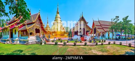 Panorama mit grünem Rasen, mittelalterlichen Schreinen (Ubosot und Viharns) und goldenen Cheedi von Wat Phra Singh, Chiang Mai, Thailand Stockfoto