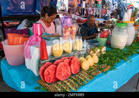 Frische Wassermelonen- und Ananasscheiben zum Verkauf auf dem Markt in Ocotlan de Morelos in den zentralen Tälern von Oaxaca, Mexiko. Stockfoto