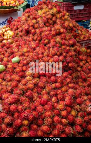 Frische Rambutanfrüchte zum Verkauf auf dem Wochenmarkt in Ocotlan de Morelos in den zentralen Tälern von Oaxaca, Mexiko. Stockfoto