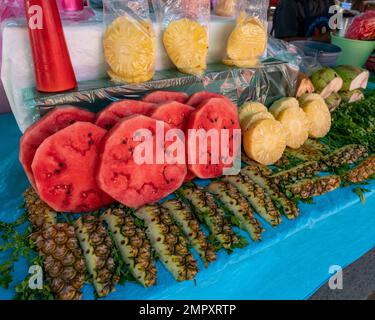 Frische Wassermelonen- und Ananasscheiben zum Verkauf auf dem Markt in Ocotlan de Morelos in den zentralen Tälern von Oaxaca, Mexiko. Stockfoto