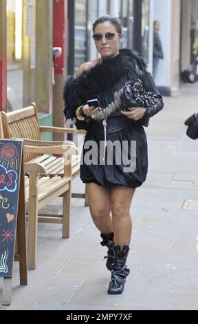 EastEnders-Star Jessie Wallace trägt ein schwarzes Kleid mit einer Fellummantelung, eine Sonnenbrille, schwarze Stiefel mit hohem Absatz und eine passende schwarze Handtasche, während sie ihr iPhone in der Hand trägt. Wallace wurde kürzlich bei den Inside Soap Awards 2011 zur besten Schauspielerin gekrönt. London, Großbritannien. 20. Oktober 2011. Stockfoto