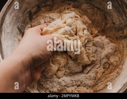 Eine Frau knettet Teig für Kekse. Kneten von Teig. Stockfoto