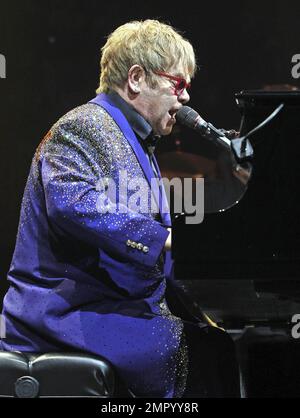 Elton John trägt eine rote gerahmte Brille und einen paillettenfarbenen Anzug mit der Aufschrift „Captain Fantastic“ auf der Rückseite, während er live im BankAtlantic Center in Sunrise, FL auftritt. 9. März 2012 Stockfoto