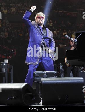 Elton John trägt eine rote gerahmte Brille und einen paillettenfarbenen Anzug mit der Aufschrift „Captain Fantastic“ auf der Rückseite, während er live im BankAtlantic Center in Sunrise, FL auftritt. 9. März 2012 Stockfoto