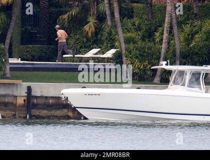 EXKLUSIV!! Die Sängerin Enrique Iglesias und ihre langjährige Freundin Anna Kournikova wurden bei einer Bootsfahrt mit ihren beiden Hunden gesehen. Das Paar wurde dabei gesehen, wie es den Fortschritt seines zukünftigen Liebsten in Miami untersucht hat. Die 30-jährige Anna, die angeblich schwanger ist, zeigte ihre Beine in einem Bikini mit Zebramuster, bedeckt mit einem pinkfarbenen Tanktop von Victoria's Secret, auf dem stand: „I only Sleep in Pink“. Anna schien sich den rechten Fuß verletzt zu haben, der in einer Milz zu sein schien. Sie schien gut zurechtzukommen, da sie einen der Hunde auf das Boot trug, aber brauchte Hilfe von Enrique, um an Bord zu gehen. Die beiden Turteltäubchen Stockfoto