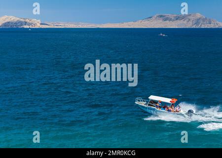 Novy Svit, Krim - 10. August 2020: Motorboot mit Touristen fährt an einem sonnigen Tag nahe der Schwarzmeerküste. Novyi Svit, Gemeinde Sudak Stockfoto