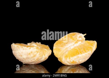 Zwei Hälften einer geschälten Orange, Makro, isoliert auf schwarzem Hintergrund. Stockfoto