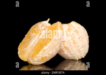 Zwei Hälften einer geschälten Orange, Makro, isoliert auf schwarzem Hintergrund. Stockfoto