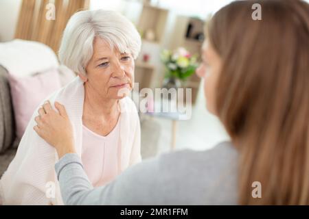 Die Erwachsene Tochter beruhigt die alte Mutter Stockfoto