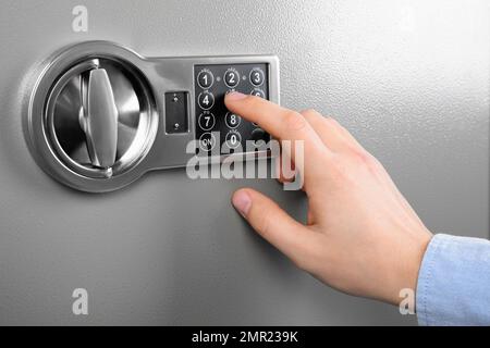 Mann öffnet Stahlsafe mit elektronischem Zahlenschloss, Nahaufnahme Stockfoto