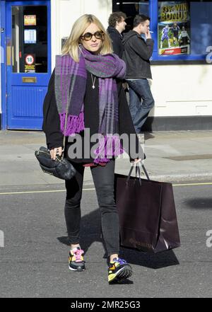 Fearne Cotton in einem sperrigen schwarzen Sweatshirt mit einem großen, violetten Schal, einer schwarzen Hose und neuen Turnschuhen. Es scheint, dass die Sneaker in verschiedenen Farben Schnürsenkel haben, eines in Pink und das andere in Blau. Könnte es eine wichtige Bedeutung hinter den kombinierten Schnürsenkeln geben? London, Großbritannien. 21. Oktober 2011. Stockfoto