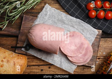 Flache Liegezusammensetzung mit leckerem Schinken auf Holztisch Stockfoto