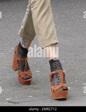 Fearne Cotton chattet mit ihrem Handy und trägt Khaki-Hosen, eine schwarze Jacke und ein blaues Hemd in Kombination mit Sandalen mit Absatz und kurzen Knöchelstrümpfen, wenn sie die BBC verlässt. London, Großbritannien. 3/22/11. Stockfoto