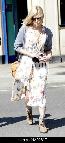 Die britische Fernseh- und Radiomoderatorin Fearne Cotton geht an einem windigen Tag mit einem Freund die Straße hinunter in London, Großbritannien. 04/27/11. Stockfoto