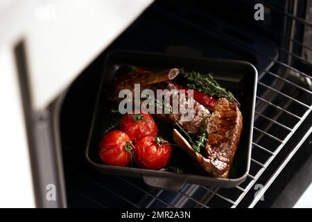 Köstliche geröstete Rippchen mit Tomaten im Ofen Stockfoto