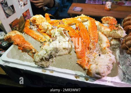 Köstliche gekochte Krabben, die am Abend auf dem offenen Markt von Ameya Yokoch zu sich genommen werden. Kleine Eiswürfel auf dem Essen. Stockfoto