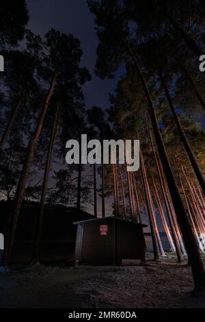 Wooden Fishing Hut am Tunstall Reservoir bei Nacht mit Schnee auf dem Boden Stockfoto