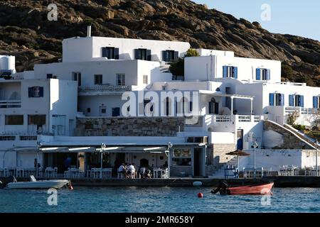 IOS, Griechenland - 3 . Juni 2021 : Blick auf ein weiß getünchtes Hotel und eine Meeresfrüchte-Taverne vor dem berühmten Mylopotas-Strand in iOS Greece Stockfoto