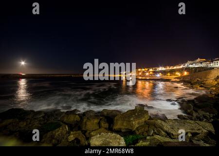 Monduntergang, Pier und Praia dos Pescadores von Pico do Futuro, dem historischen Zentrum des Dorfes Ericeira, an einem Winterabend in Portugal Stockfoto