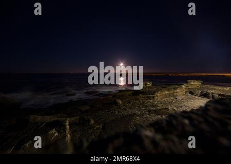 Monduntergang und Pier von Pico do Futuro, dem historischen Zentrum des Dorfes Ericeira, an einem Winterabend in Portugal Stockfoto