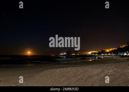 Moonset und Praia do Sul Ericeira Village Portugal Stockfoto