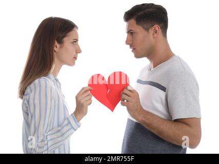 Ein Paar reißt das Papierherz auf weißem Hintergrund. Beziehungsprobleme Stockfoto