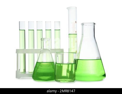 Verschiedene Laborglasgeräte mit hellgrüner Flüssigkeit, isoliert auf weiß Stockfoto