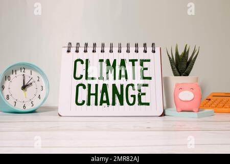 Der Protestant hält ein Plakat mit dem Text Klimawandel ist real und verschwommene Sicht auf die industrielle Fabrik im Hintergrund. Stockfoto