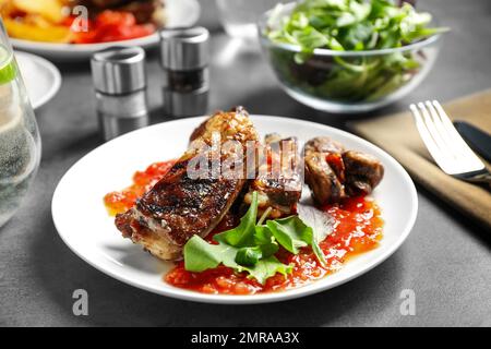 Leckere gegrillte Rippchen auf grauem Tisch Stockfoto