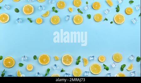 Rahmen aus Zitronenscheiben, Minze und Eis auf hellblauem Hintergrund, Draufsicht mit Platz für Text. Limonade-Layout Stockfoto