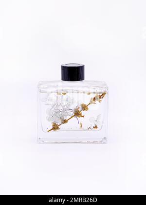 Das Holzaroma bleibt in einem Glaskolben haften, der mit flüssiger Geschmackssubstanz gefüllt ist, isoliert auf weißem Hintergrund, Seitenansicht. Hochwertiges Foto Stockfoto