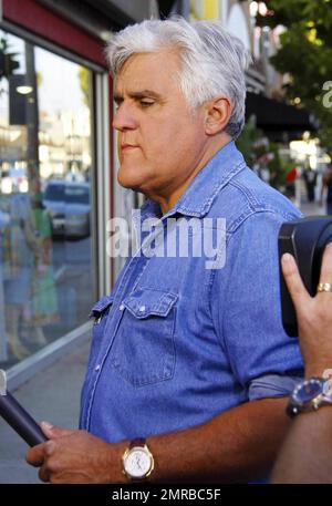 Jay Leno zeigt einem Passanten Fotos von einigen der weltweit bekanntesten Sehenswürdigkeiten, während er den beliebten Abschnitt „Jaywalk“ für „The Tonight Show with Jay Leno“ filmt. West Hollywood, Kalifornien. 8/5/10. . Stockfoto