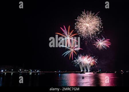 Ein malerischer Blick auf farbenfrohe Feuerwerksproben über dem Hafen von Queen Anne's Battery bei Nacht Stockfoto