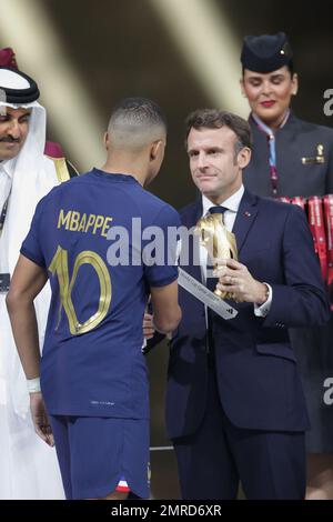 Emmanuel Macron (Präsident Frankreichs) überreicht Kylian Mbappe (Frankreich) beim Finalspiel der FIFA-Weltmeisterschaft Katar 2022 zwischen Argentinien und Frankreich im Lusail Stadium die Trophäe. Endergebnis: Argentinien 3:3 (Penalty 4:2) Frankreich. Stockfoto