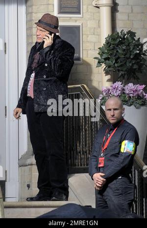 Schauspieler John Malkovich raucht eine Zigarette, während er am Drehort „Red 2" in London, Großbritannien, teilnimmt. 12. November 2012 Stockfoto