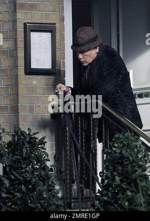 Schauspieler John Malkovich raucht eine Zigarette, während er am Drehort „Red 2" in London, Großbritannien, teilnimmt. 12. November 2012 Stockfoto