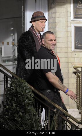 Schauspieler John Malkovich raucht eine Zigarette, während er am Drehort „Red 2" in London, Großbritannien, teilnimmt. 12. November 2012 Stockfoto