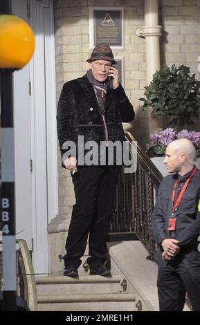 Schauspieler John Malkovich raucht eine Zigarette, während er am Drehort „Red 2" in London, Großbritannien, teilnimmt. 12. November 2012 Stockfoto